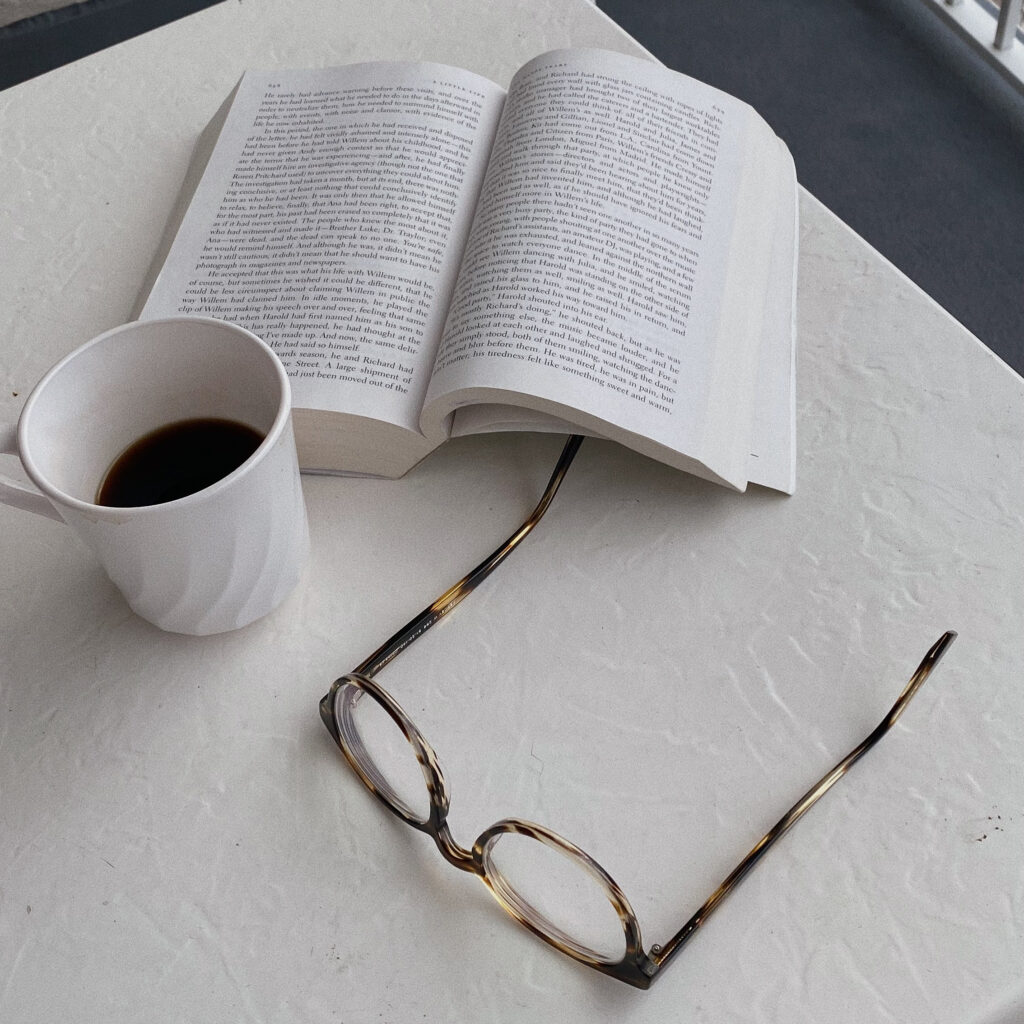Desk with book, coffee and glasses